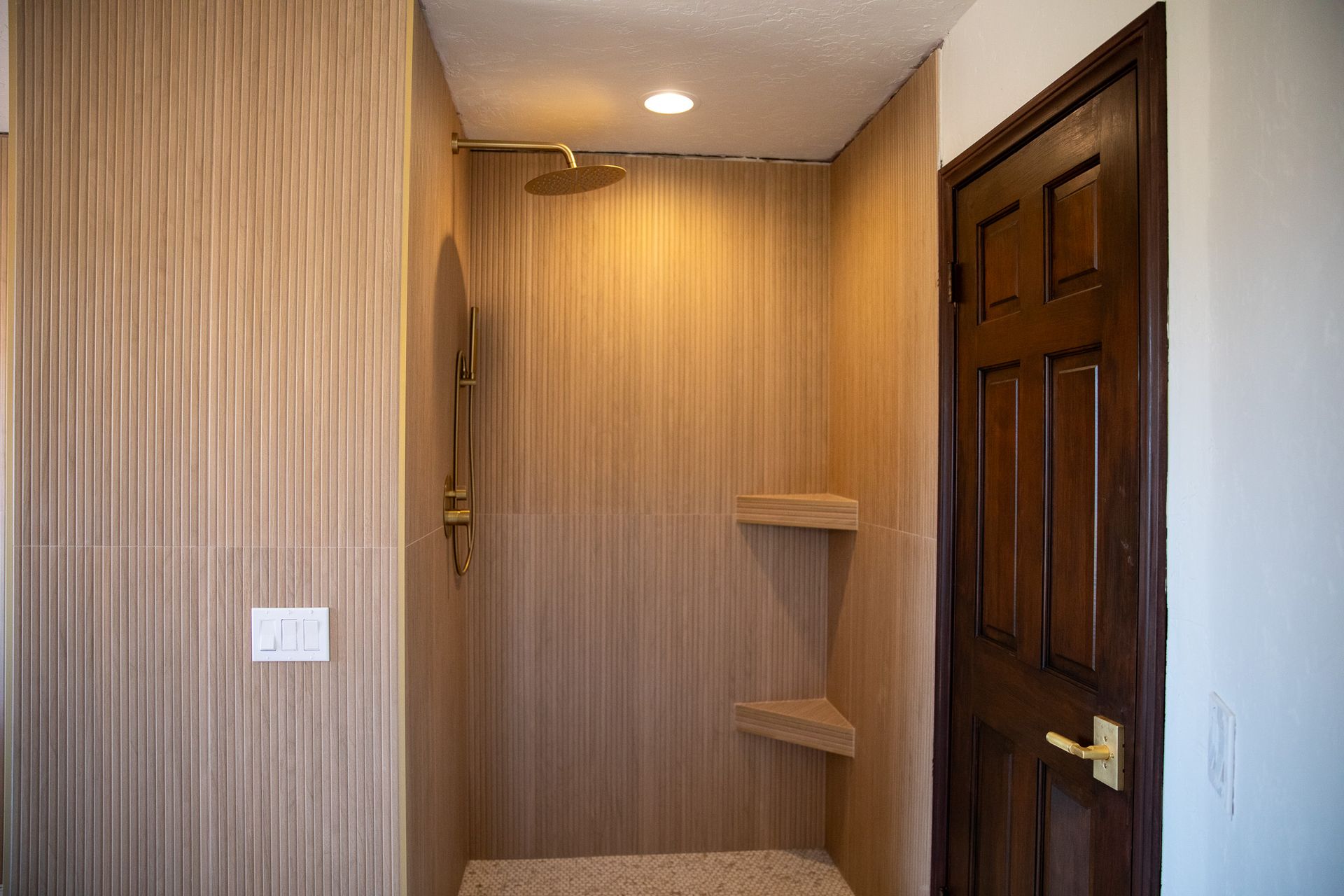 A bathroom with a walk in shower and a door.
