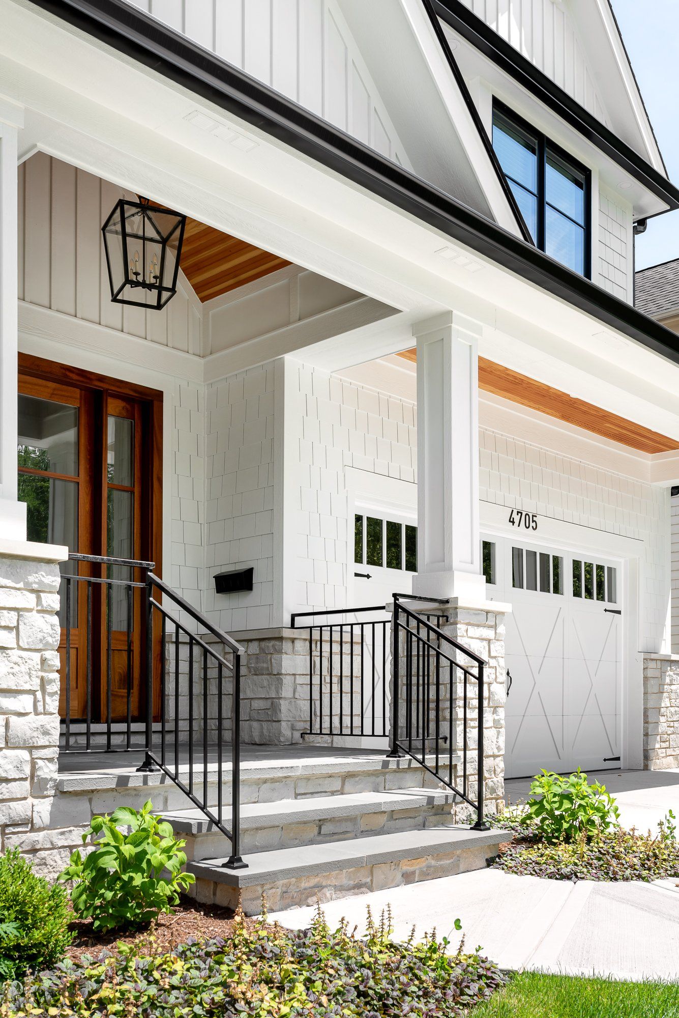A white house with a porch and stairs leading to the front door.