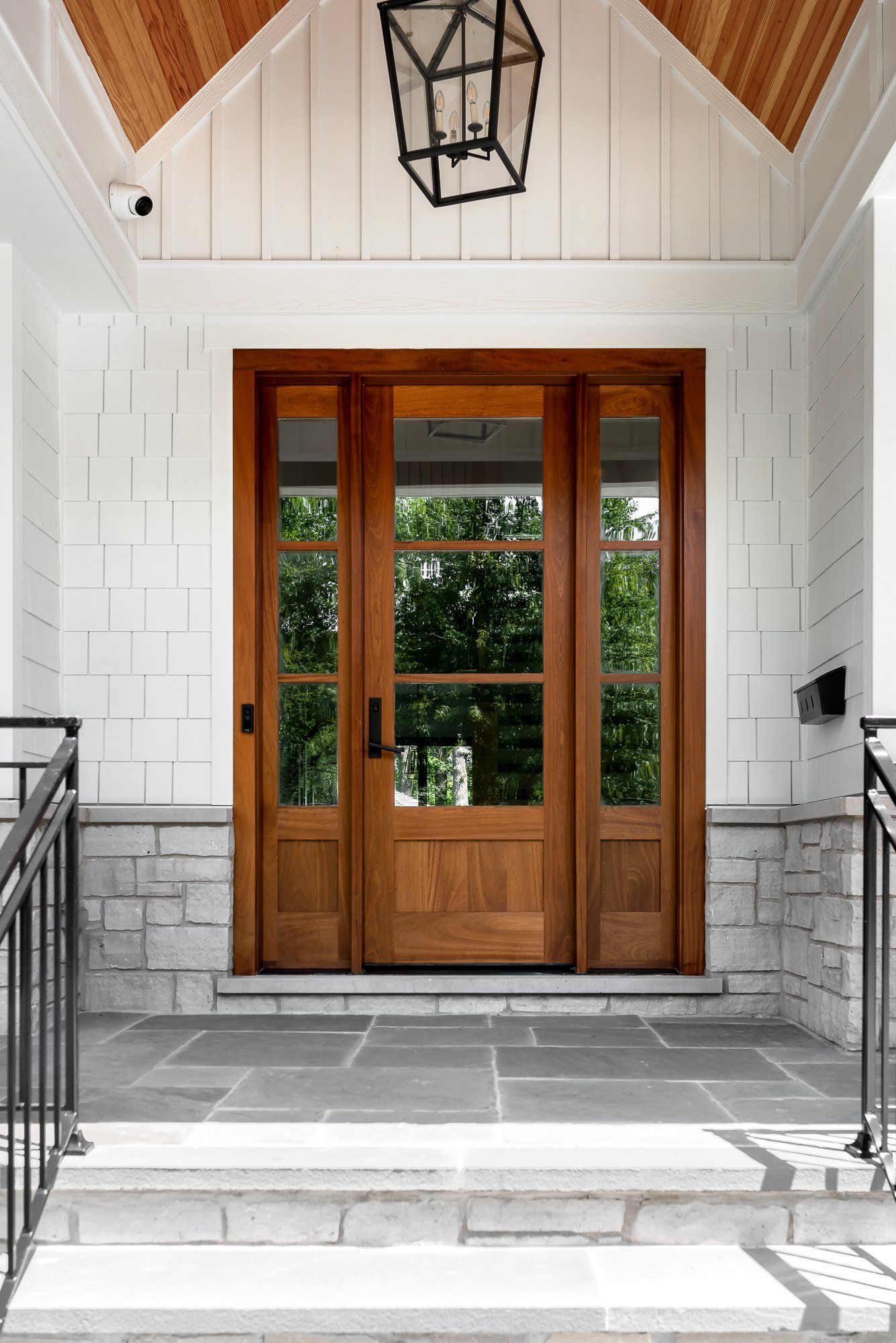 The front door of a house with a lantern hanging from the ceiling.