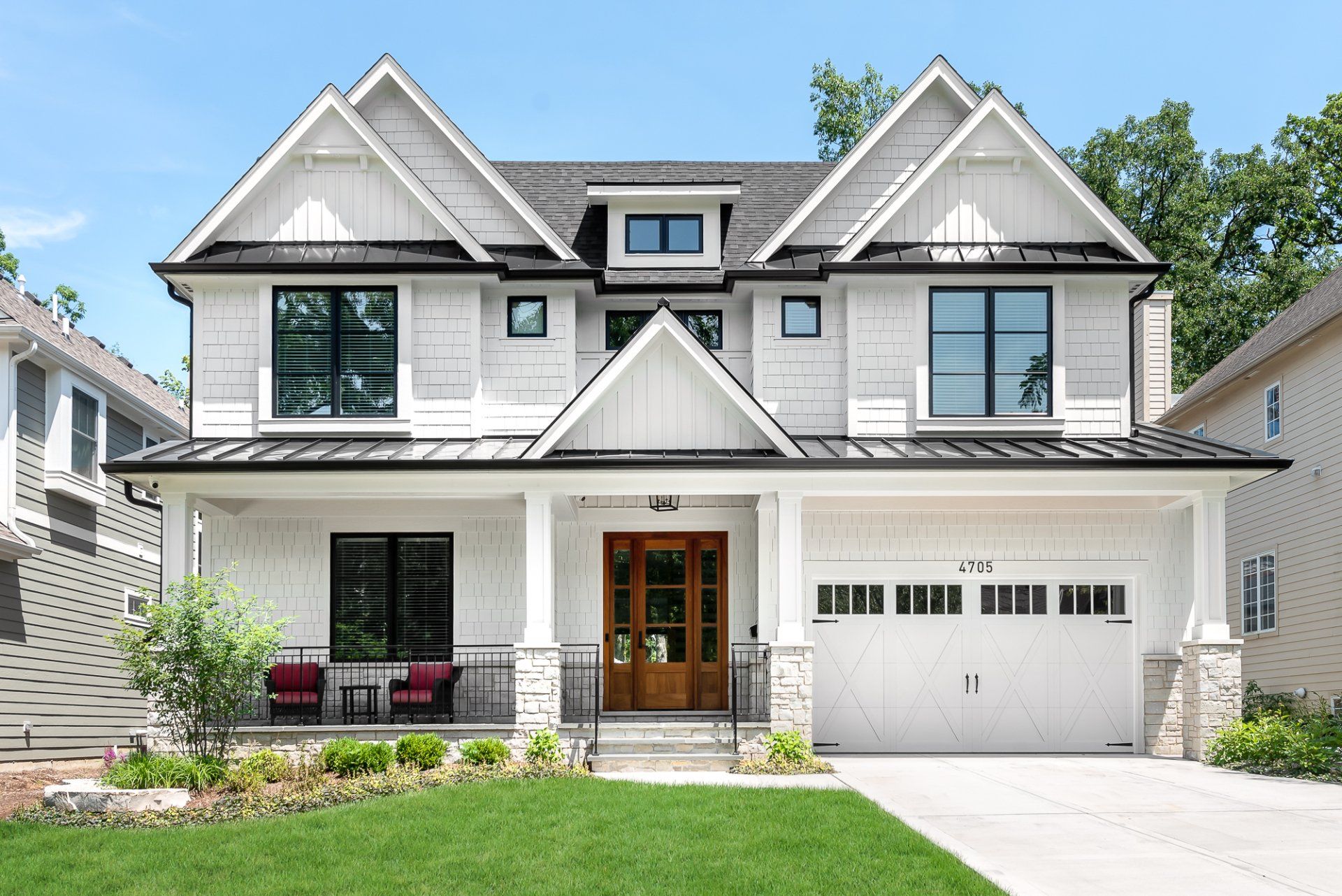 A large white house with a large garage and a porch
