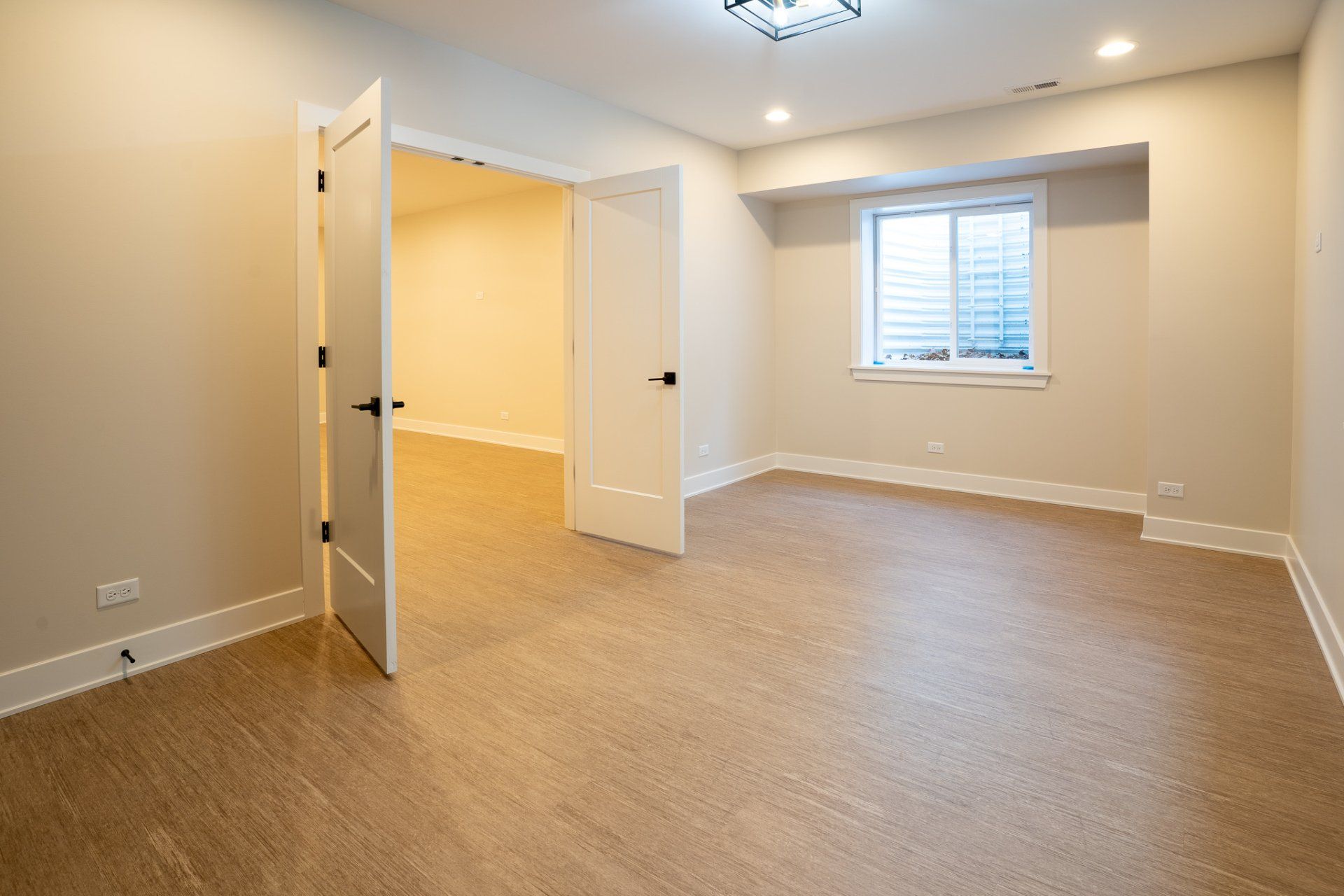 An empty room with a window and a door.