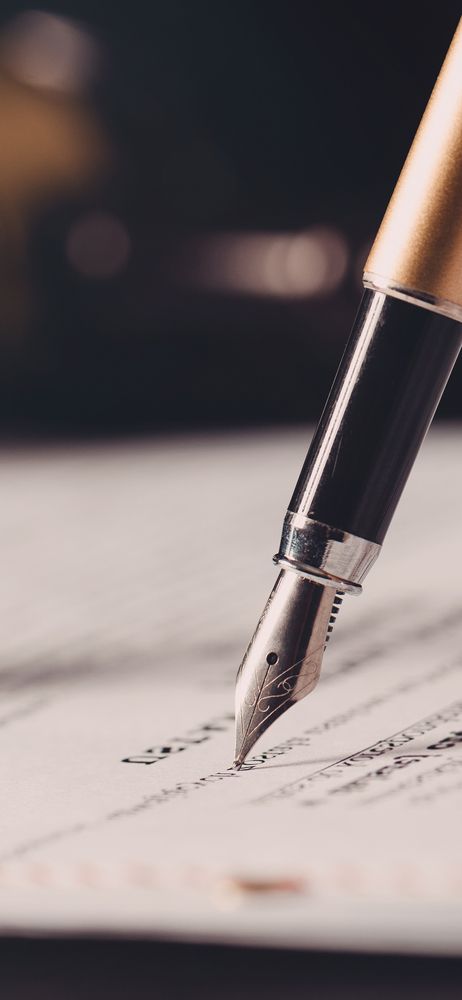 A fountain pen is writing on a piece of paper.