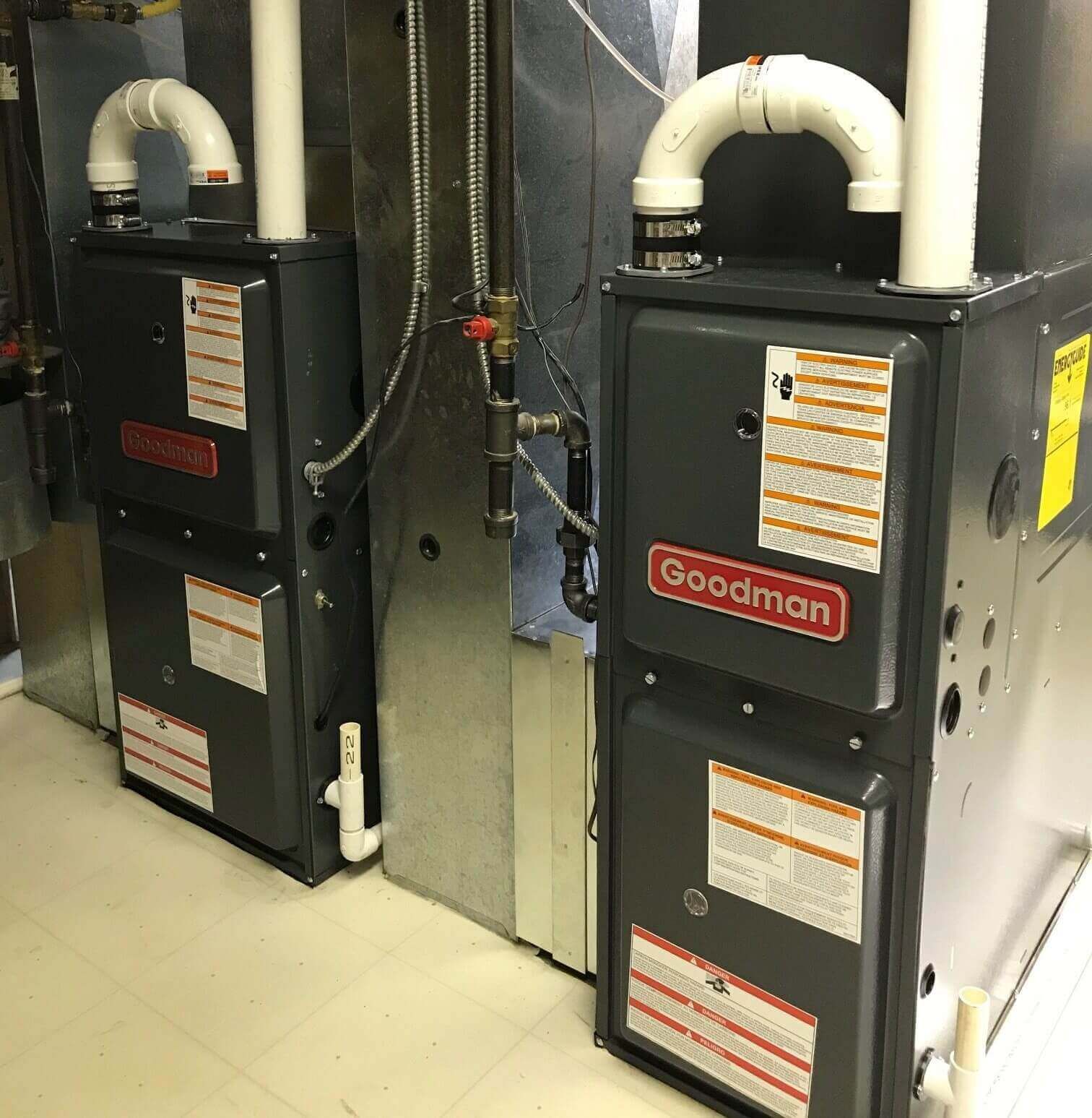 A gloved hand uses a screwdriver on the metal pipe component of an open wall-mounted boiler.