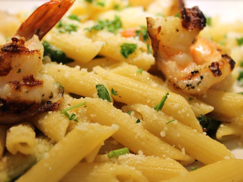 Grilled shrimp and penne pasta with parmesan and parsley.