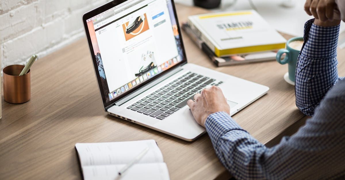 A man is sitting at a desk using a laptop computer.