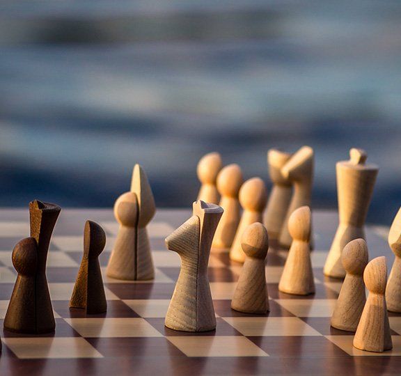 Chessboard with wooden chess pieces in a soft light. The pieces are arranged and ready for a game.