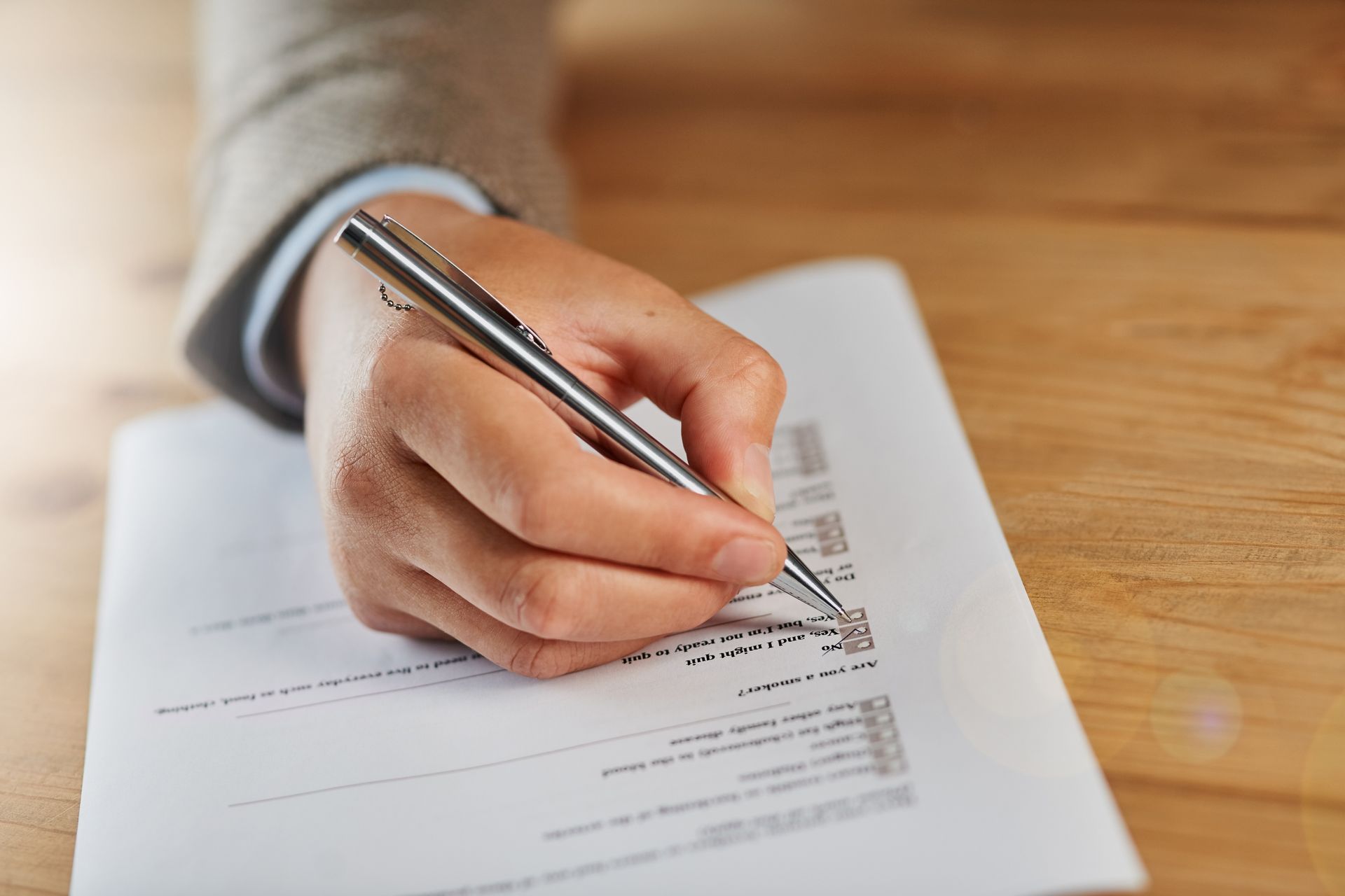 A person is writing on a piece of paper with a pen.
