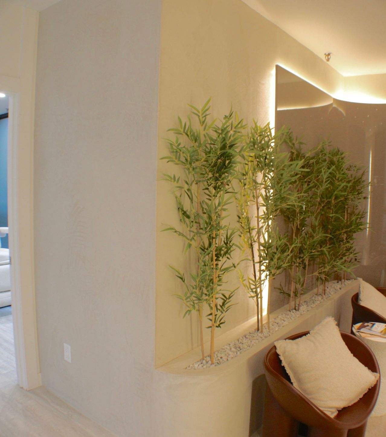 Espace intérieur avec plantes de bambou dans une jardinière intégrée et coin salon.