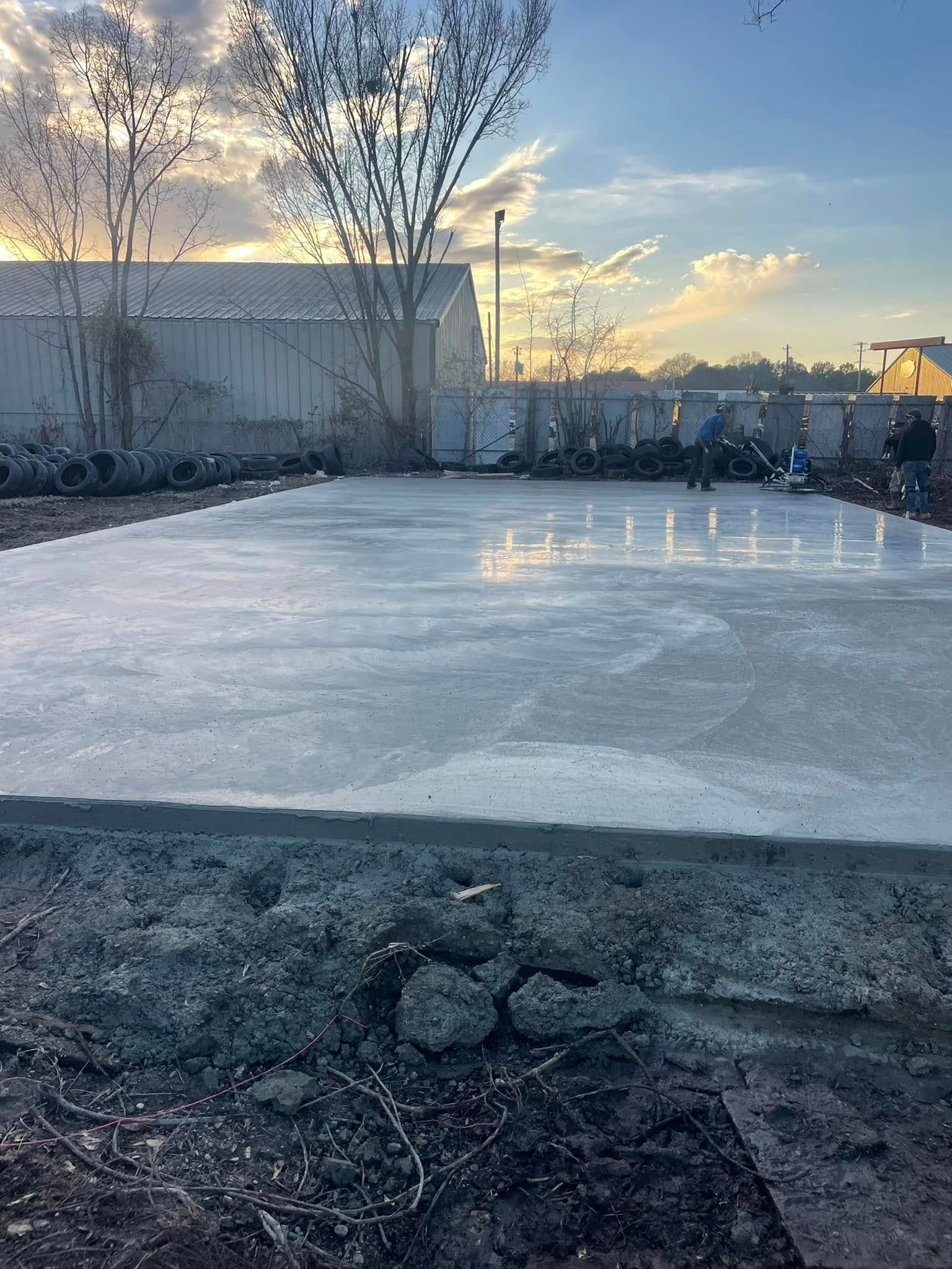 Frozen backyard pond with leafless trees and a sunset sky reflected on the ice