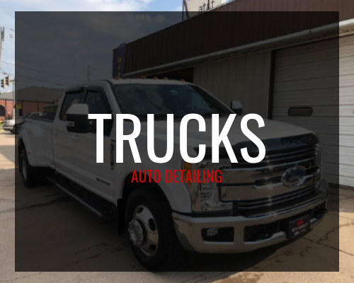 White pickup truck parked outside a building with “TRUCKS” and “AUTO REPAIR” text overlay