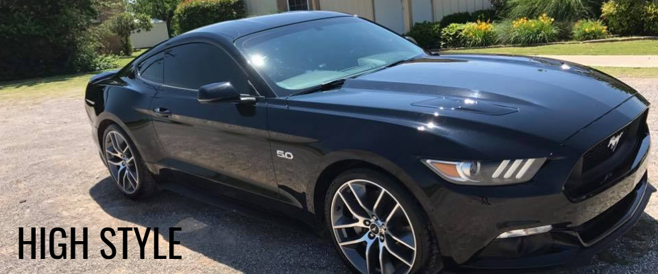 Black sports coupe parked outdoors with “HIGH STYLE” text on the image