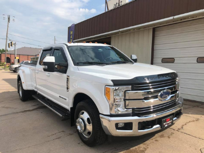 White Ford pickup truck parked outside a building on a sunny street.