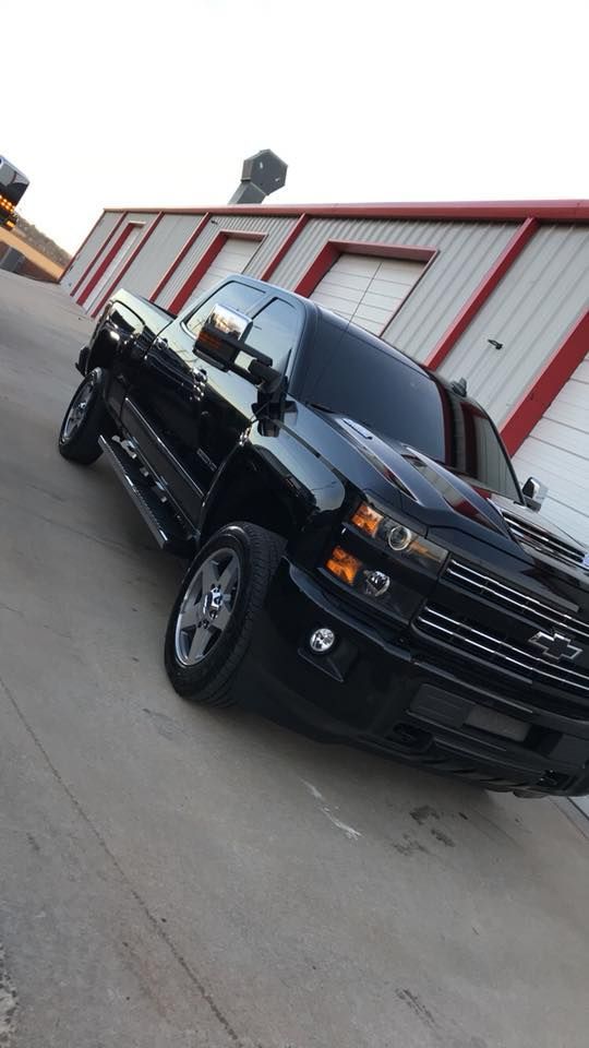 Black pickup truck parked at an angle outside a red-and-white building