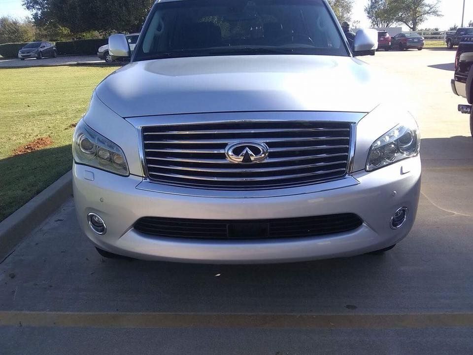 Front view of a silver Infiniti SUV parked on a driveway in bright daylight