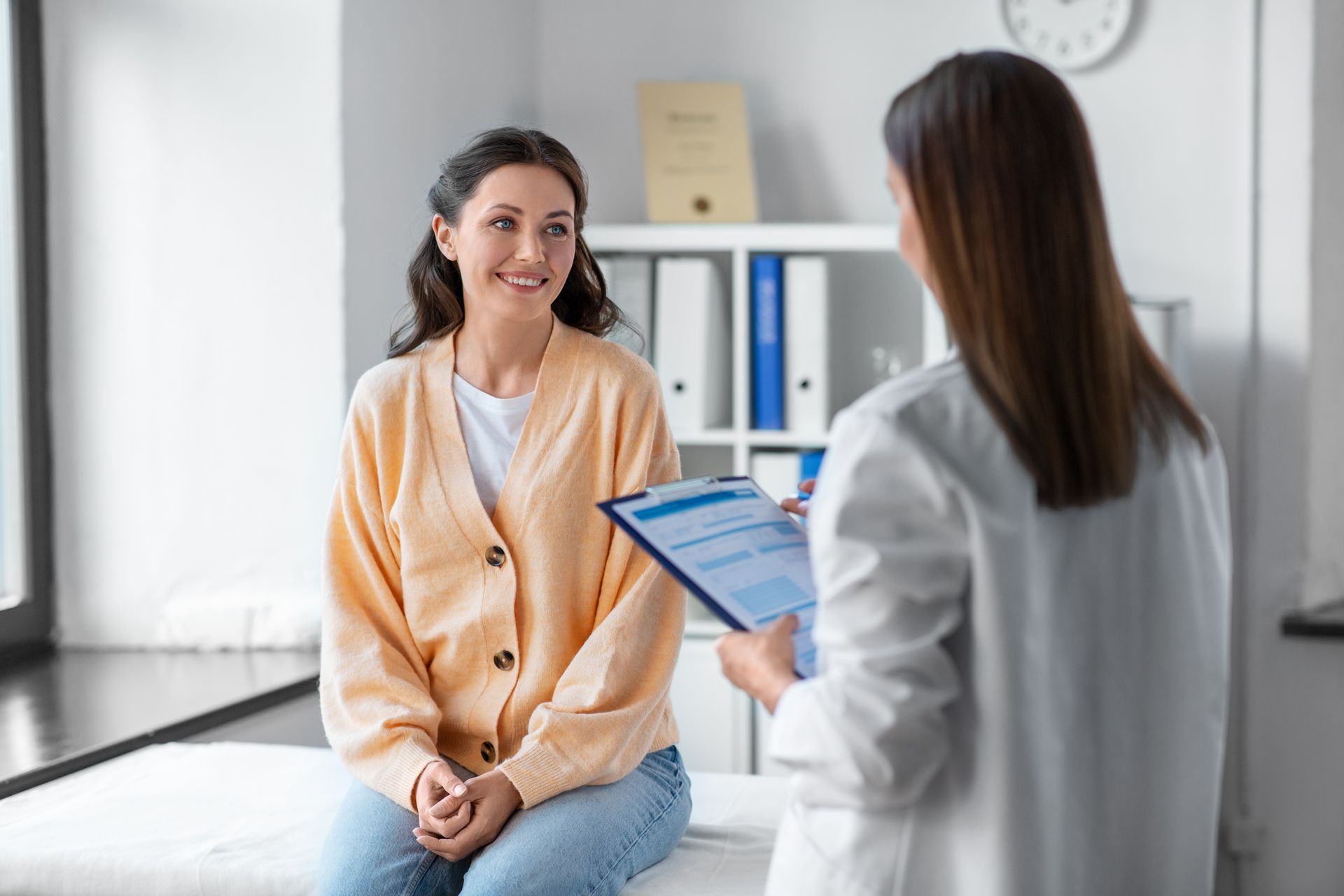Doctor consulting a smiling patient in a bright clinic room