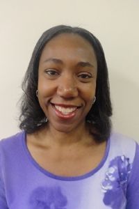 Smiling person in a purple top against a plain light background