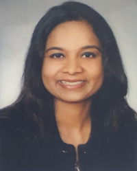 Portrait of a smiling person with long dark hair against a light background