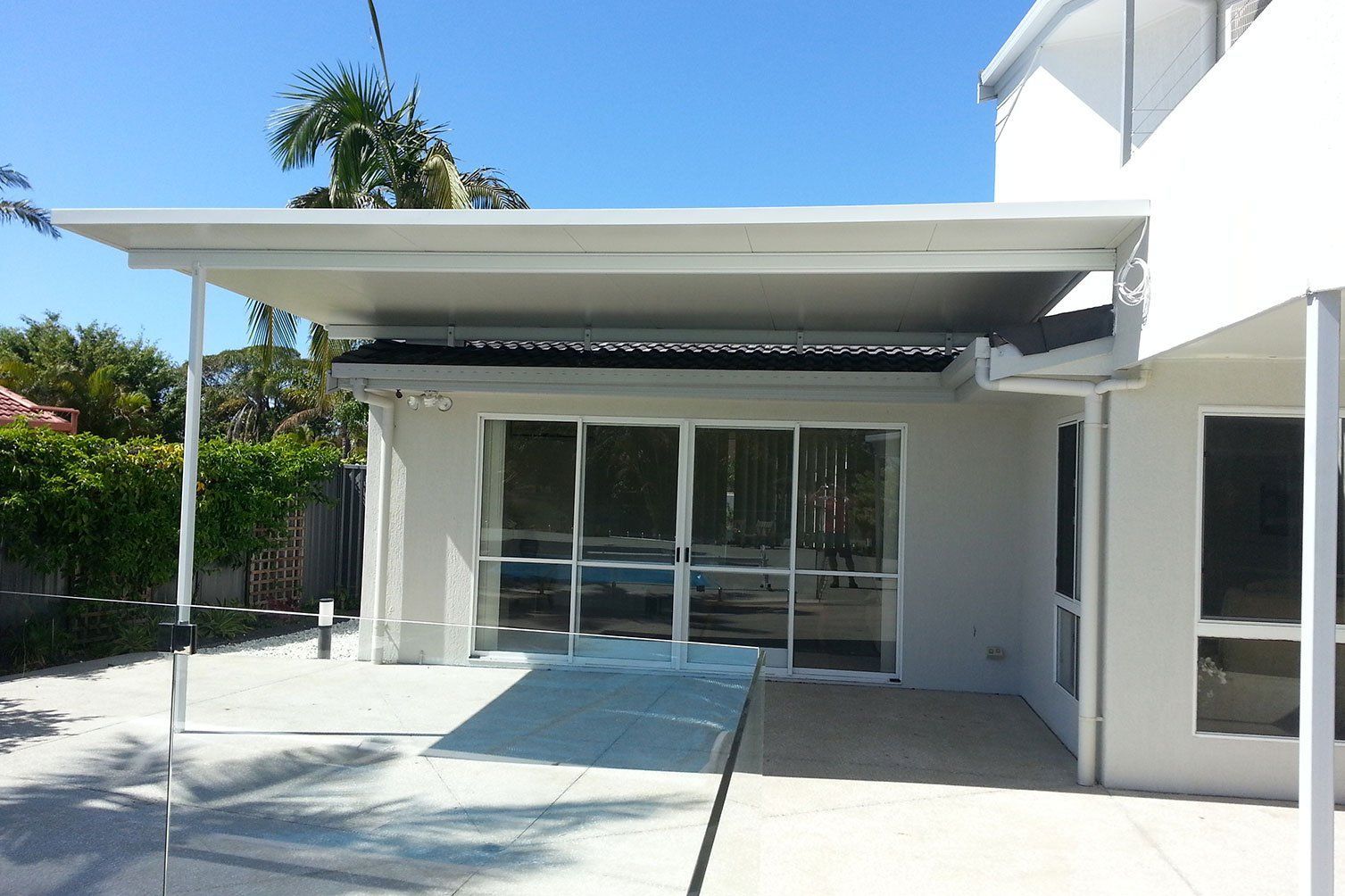 Modern white house patio with sliding glass doors and a covered entryway