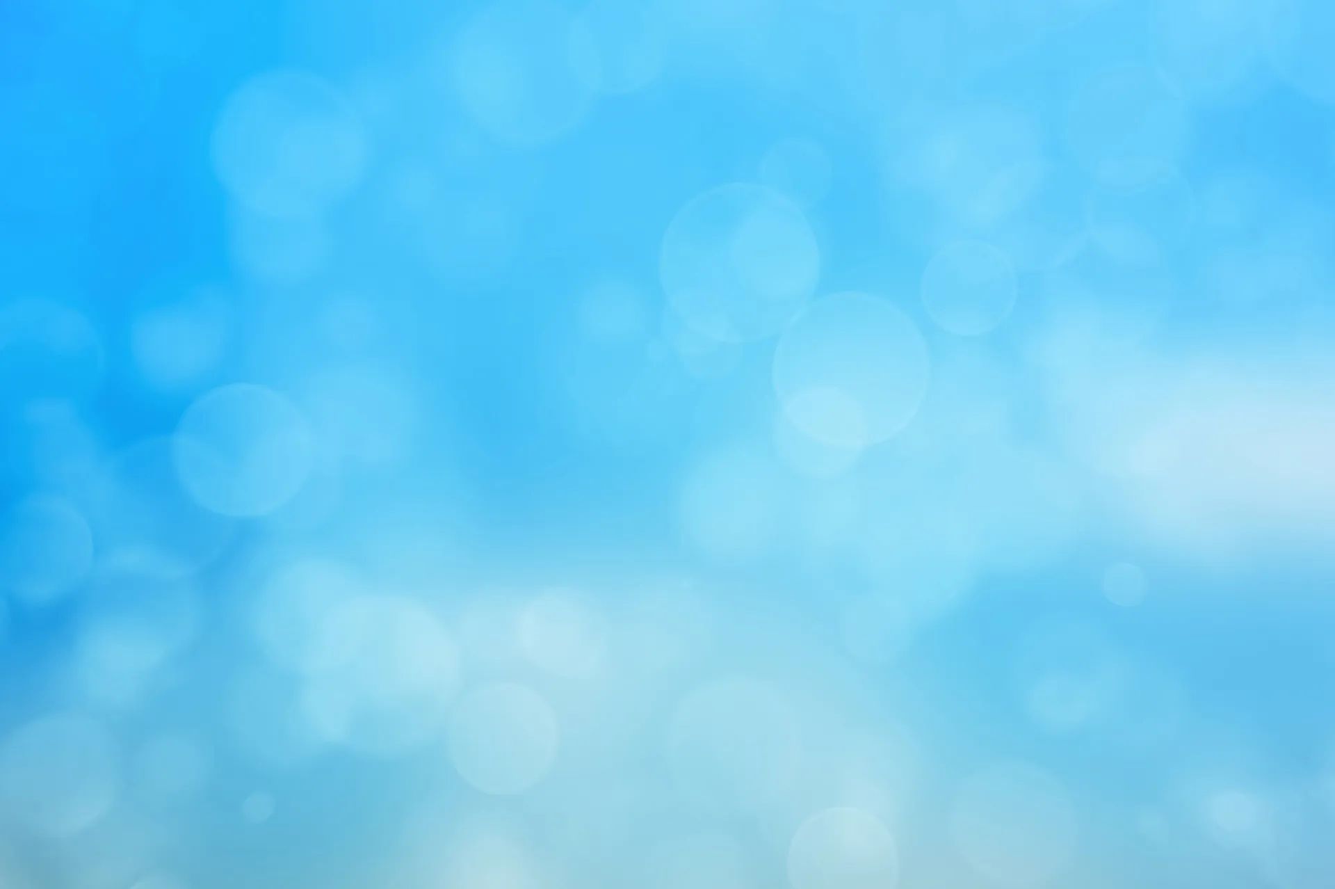 Soft blue abstract bokeh background with blurred light circles