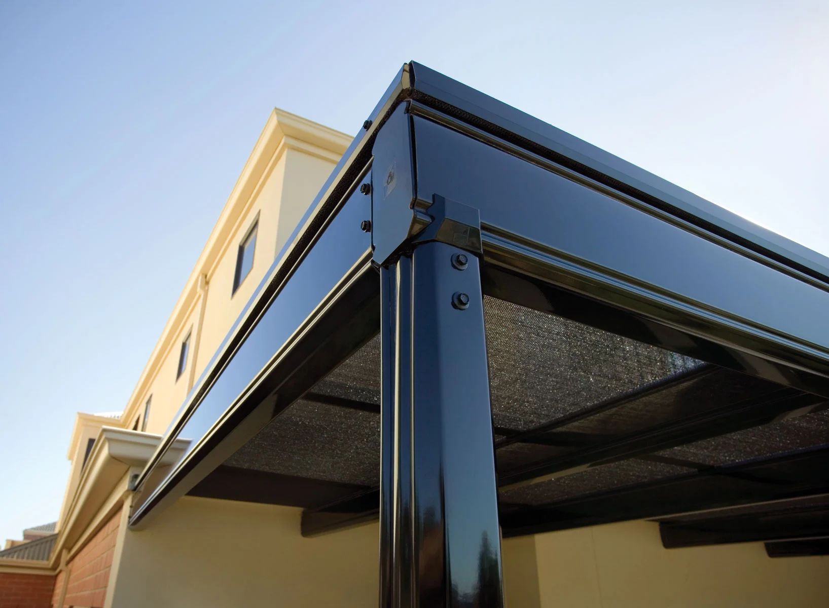 Blue awning attached to a beige building against a clear sky