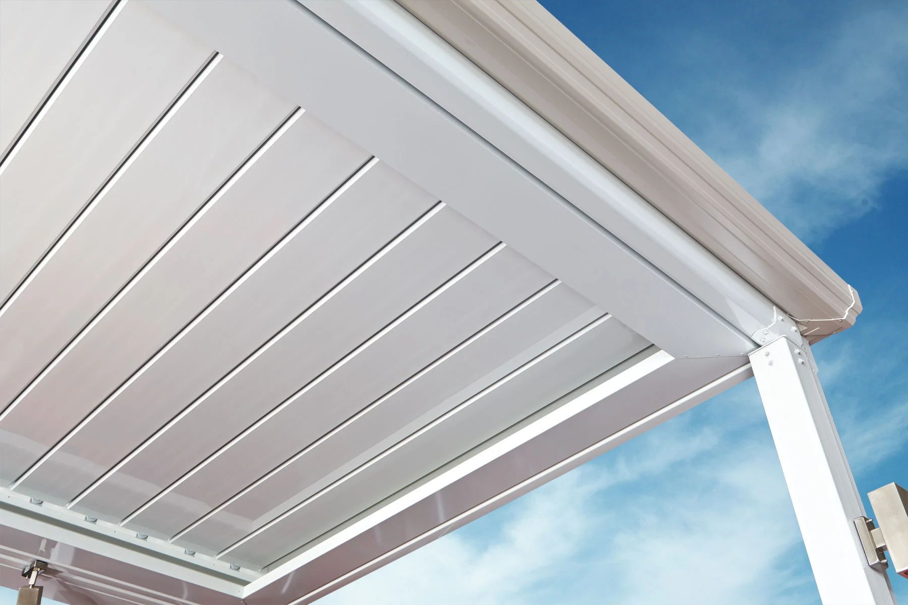 White slatted patio pergola roof against a blue sky