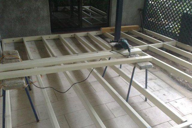 Circular saw on wooden floor framing inside a construction area