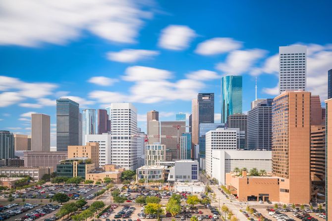 Downtown skyline with modern high-rise buildings under a blue sky with scattered clouds