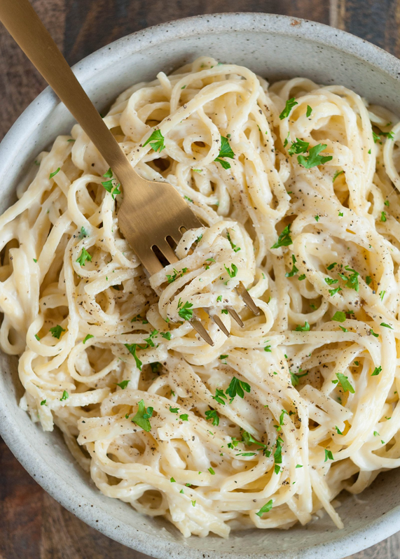 A bowl of pasta with a fork in it.