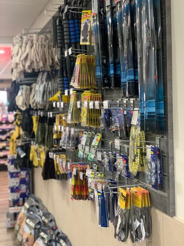 A bunch of tools are hanging on a wall in a store.