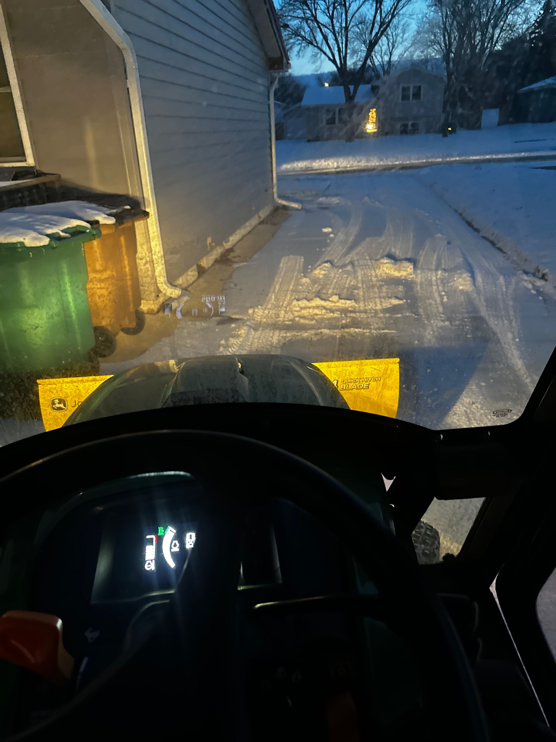 A person is driving a snow plow in the snow.