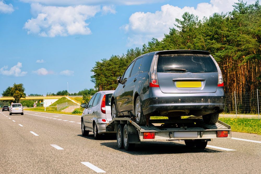 A Car Is Being Towed by A Tow Truck on A Highway — Aussie Car Transporters In Welshpool, WA