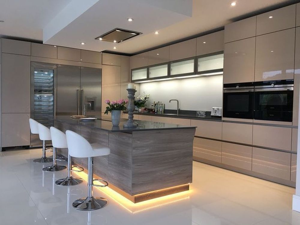Modern kitchen with glossy cabinets, island seating, and under-cabinet lighting