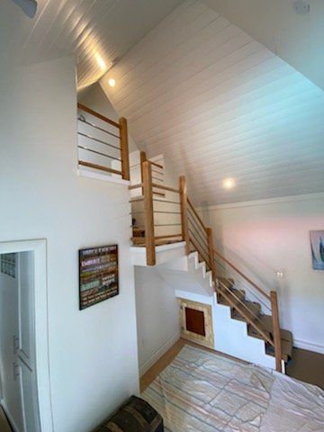 Bright white stairwell with wooden railings and carpeted steps in a modern home.