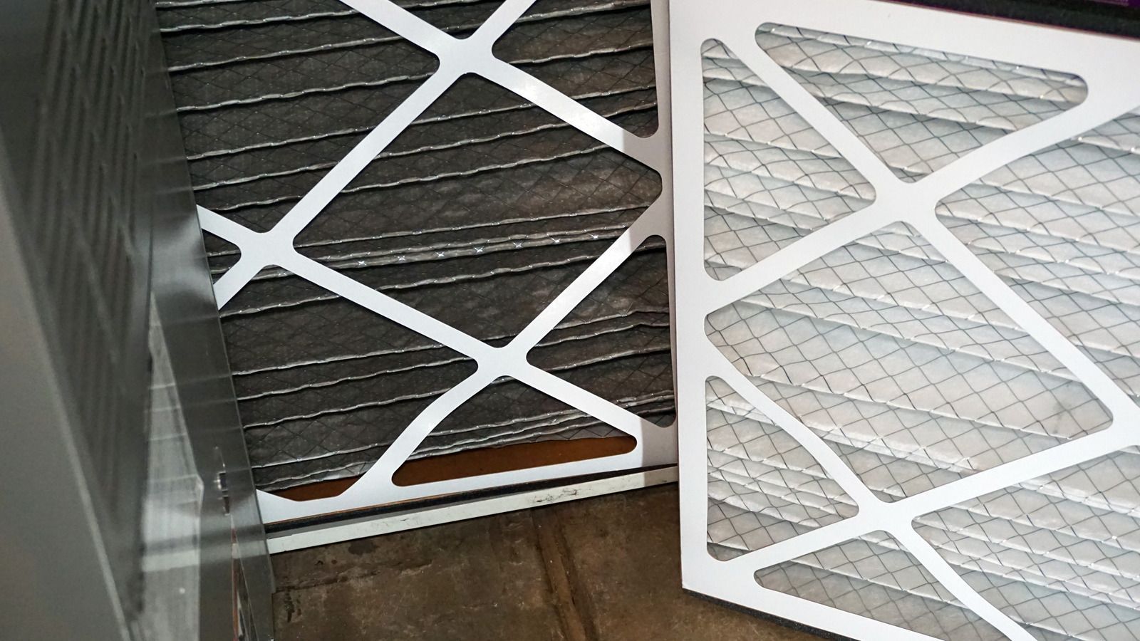 Two air filters are sitting next to each other on a wooden floor.