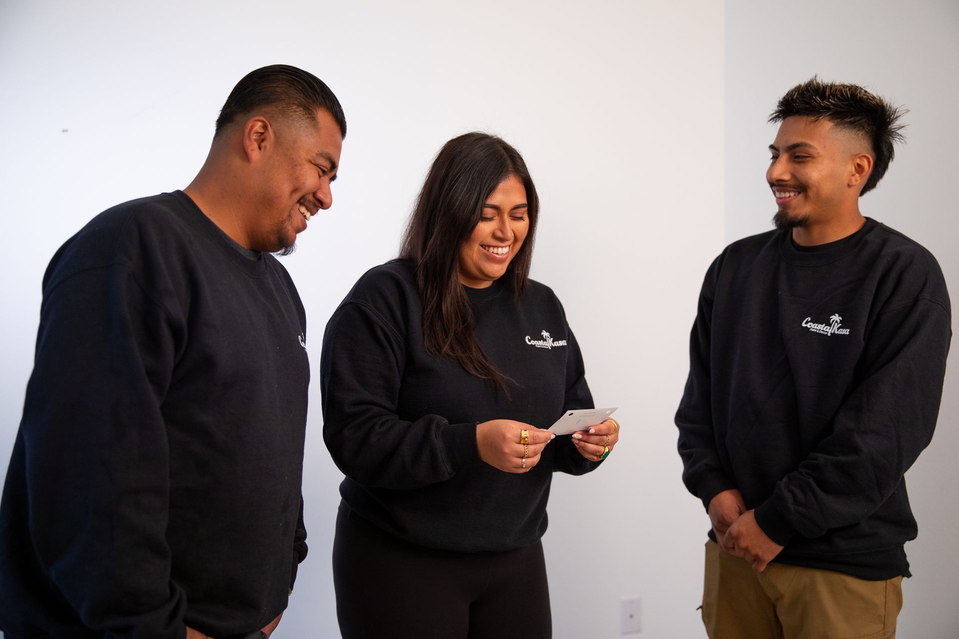 a man and two women are standing next to each other in a room .