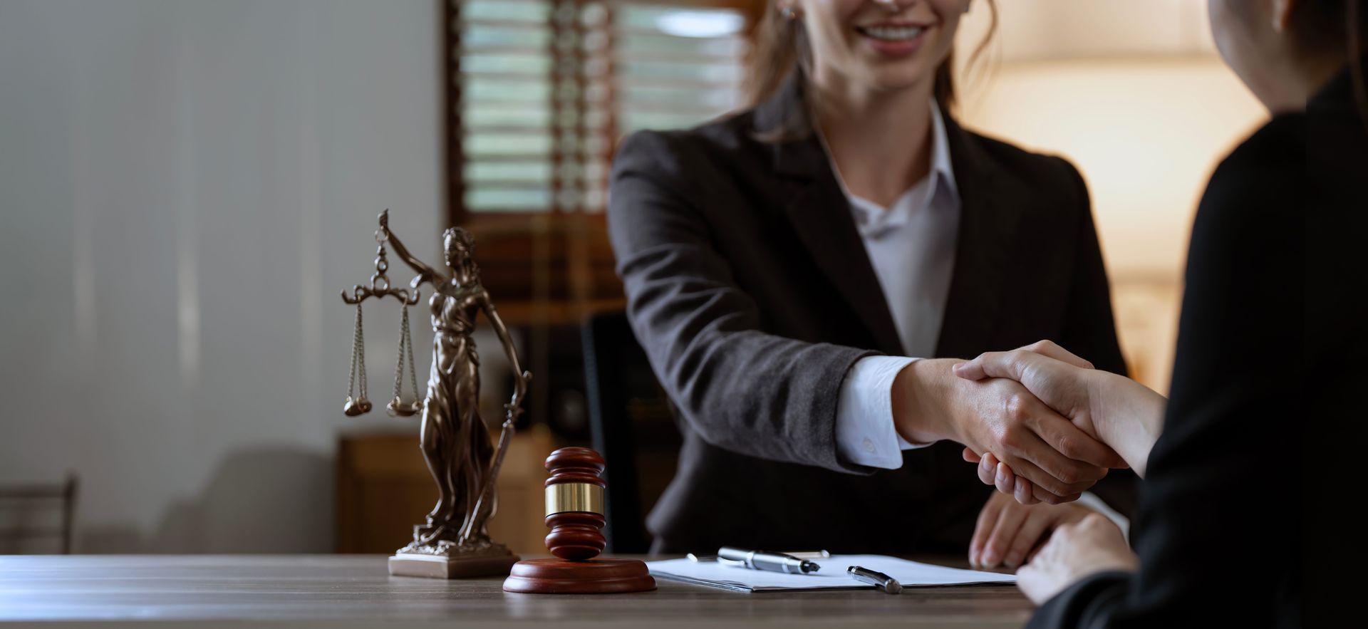 A woman is shaking hands with a man in a courtroom.