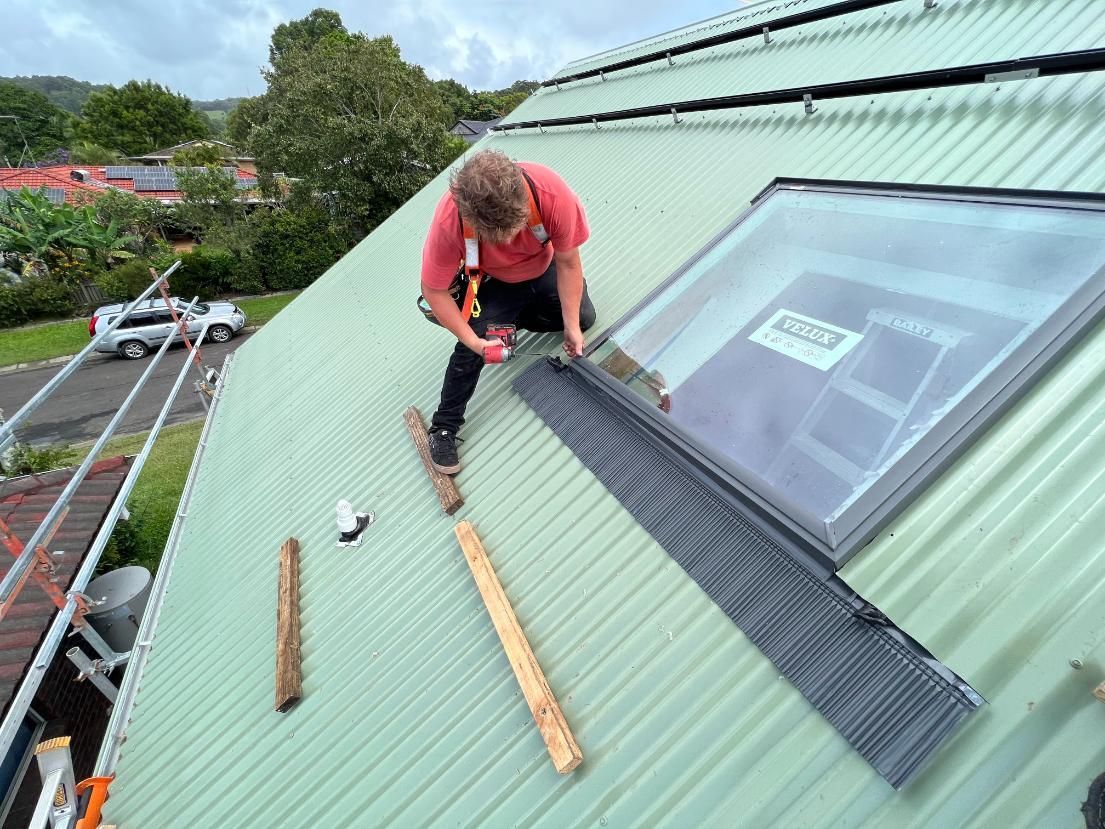 A Roofer Installing a Skylight on a Green Corrugated Metal Roof — Blue Sky Roofing NSW In Tweed Heads, NSW