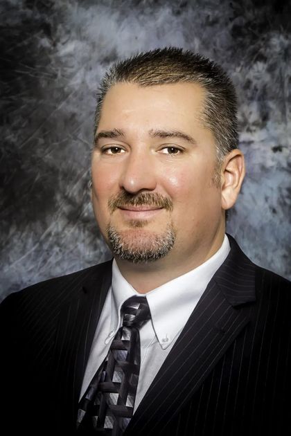 A man in a suit and tie is smiling for the camera.