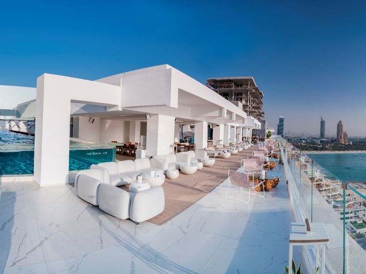 A large white building with a swimming pool in the middle of it.