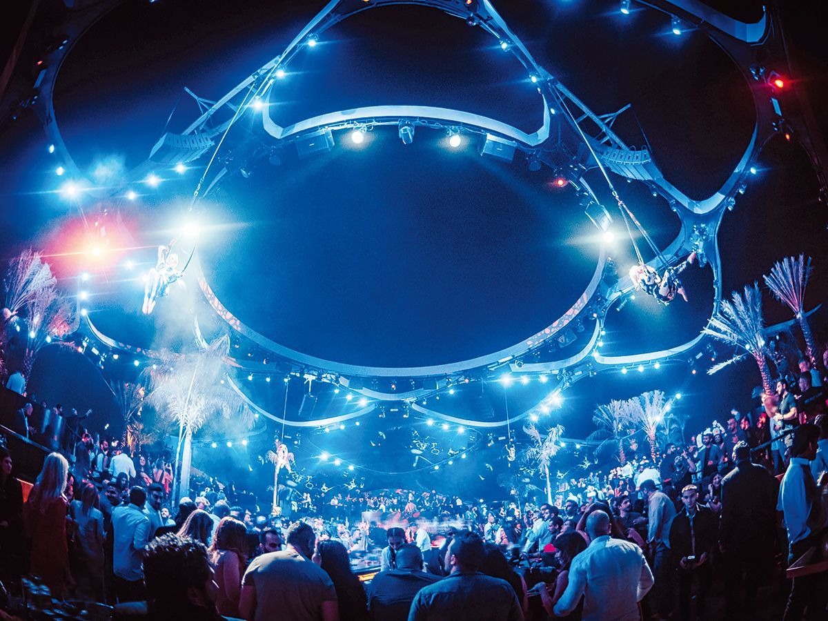A crowd of people are standing in front of a stage at a concert.