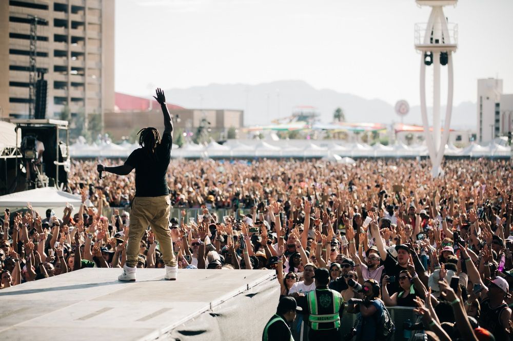 A man is standing on a stage in front of a crowd at a concert.