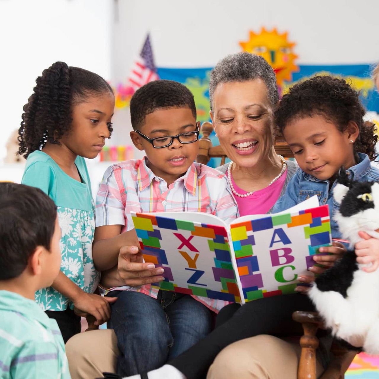 A woman is reading a book to a group of children