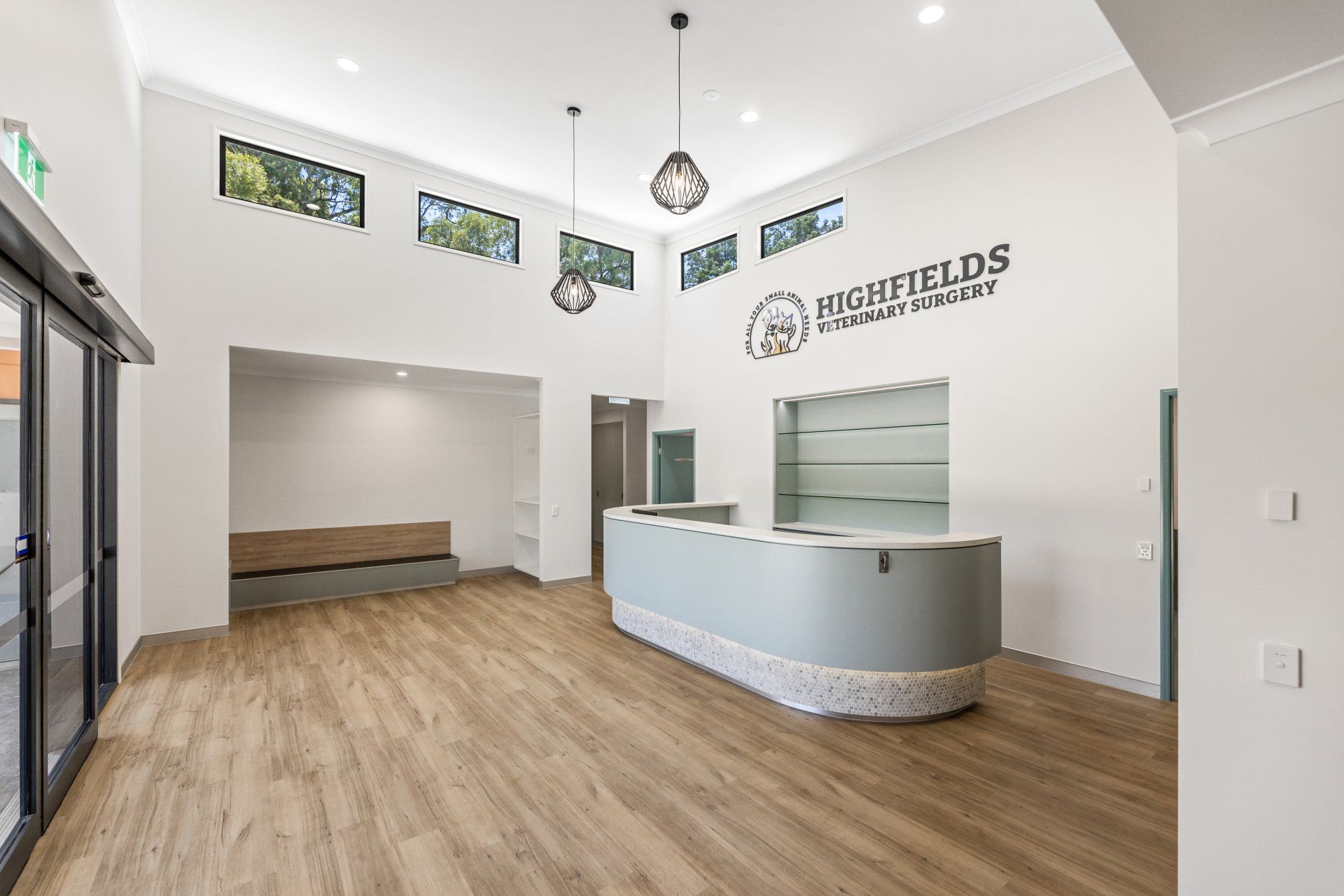 Modern office lobby with reception desk, wood flooring, and branded wall signage