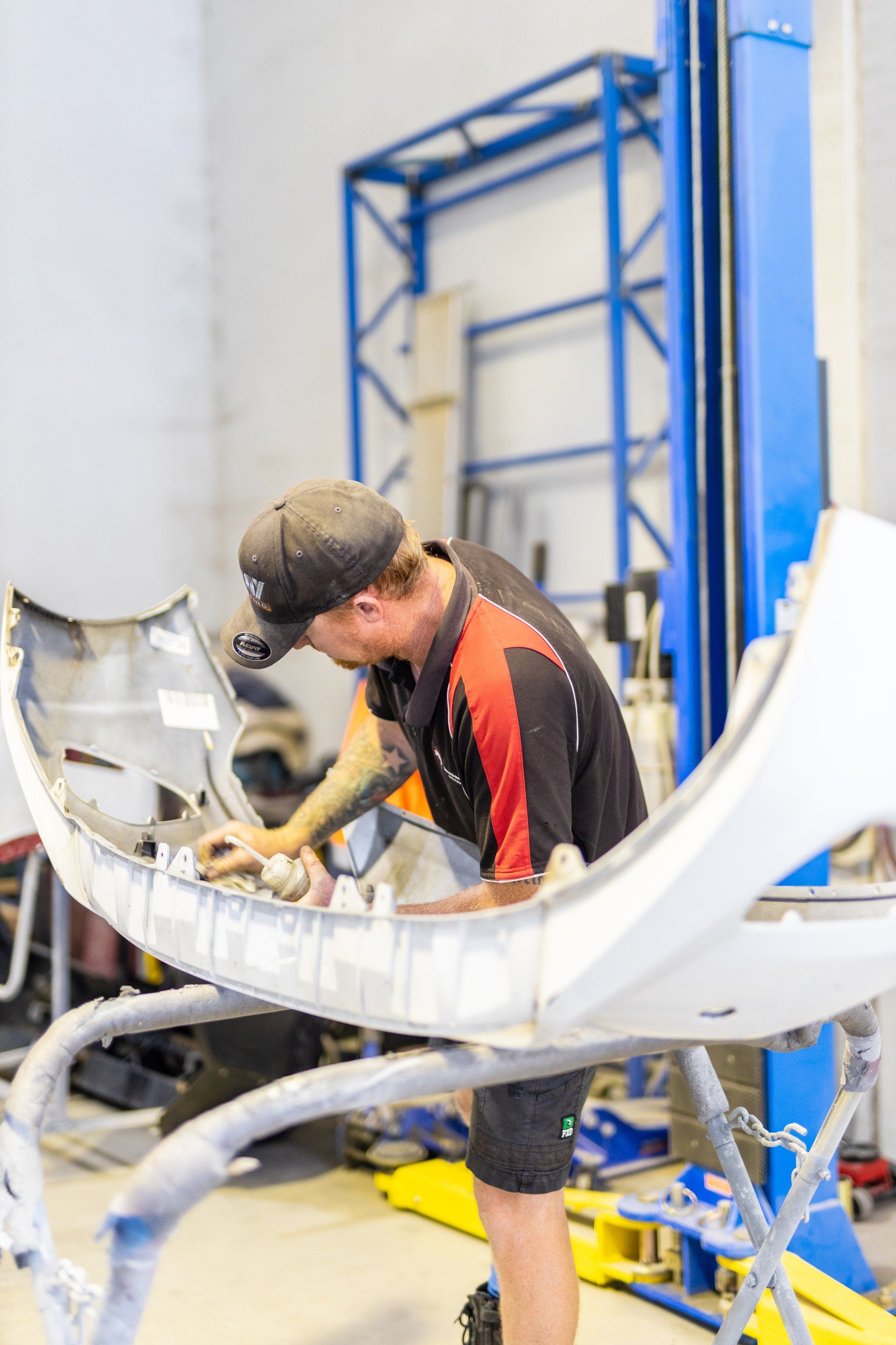 Technician inspecting the inside of a large white aircraft fuselage in a workshop