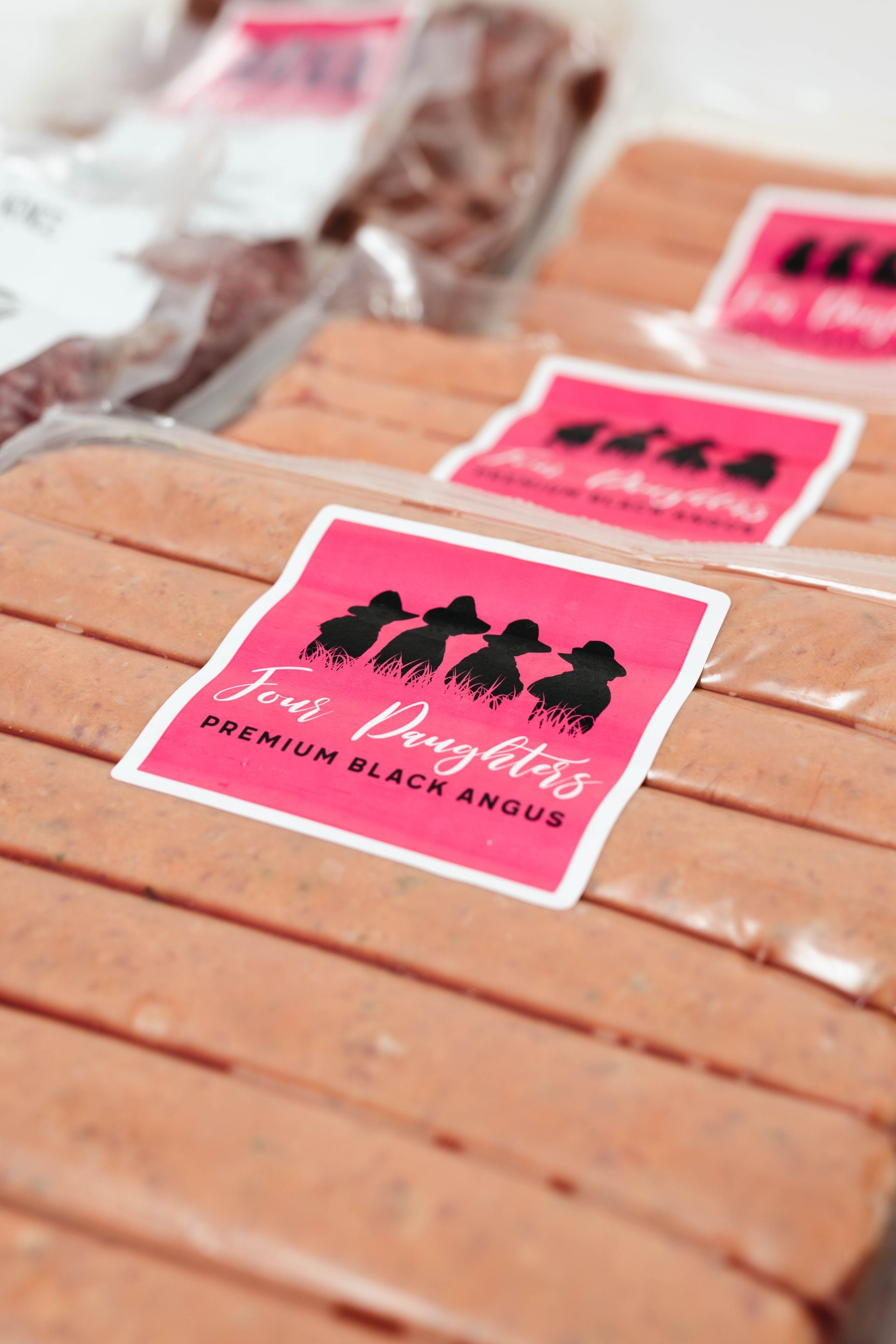 Pink-labeled wrapped snacks stacked in rows, with black silhouettes on the packaging