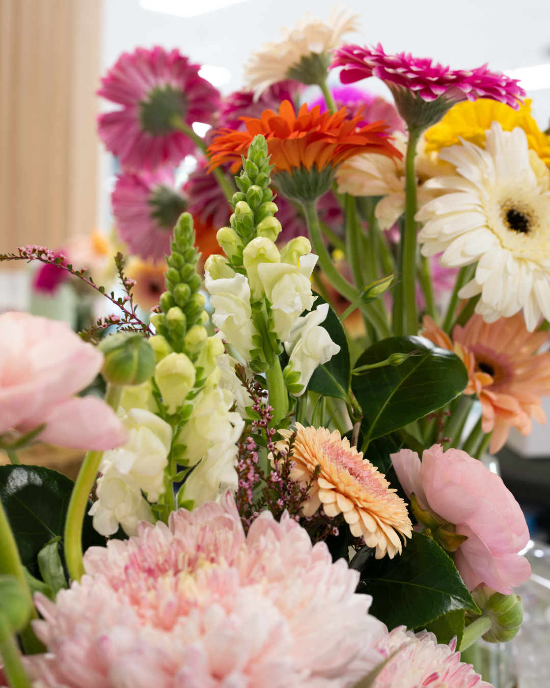 Bouquet of colorful flowers with pink, white, yellow, and orange blooms in a vase