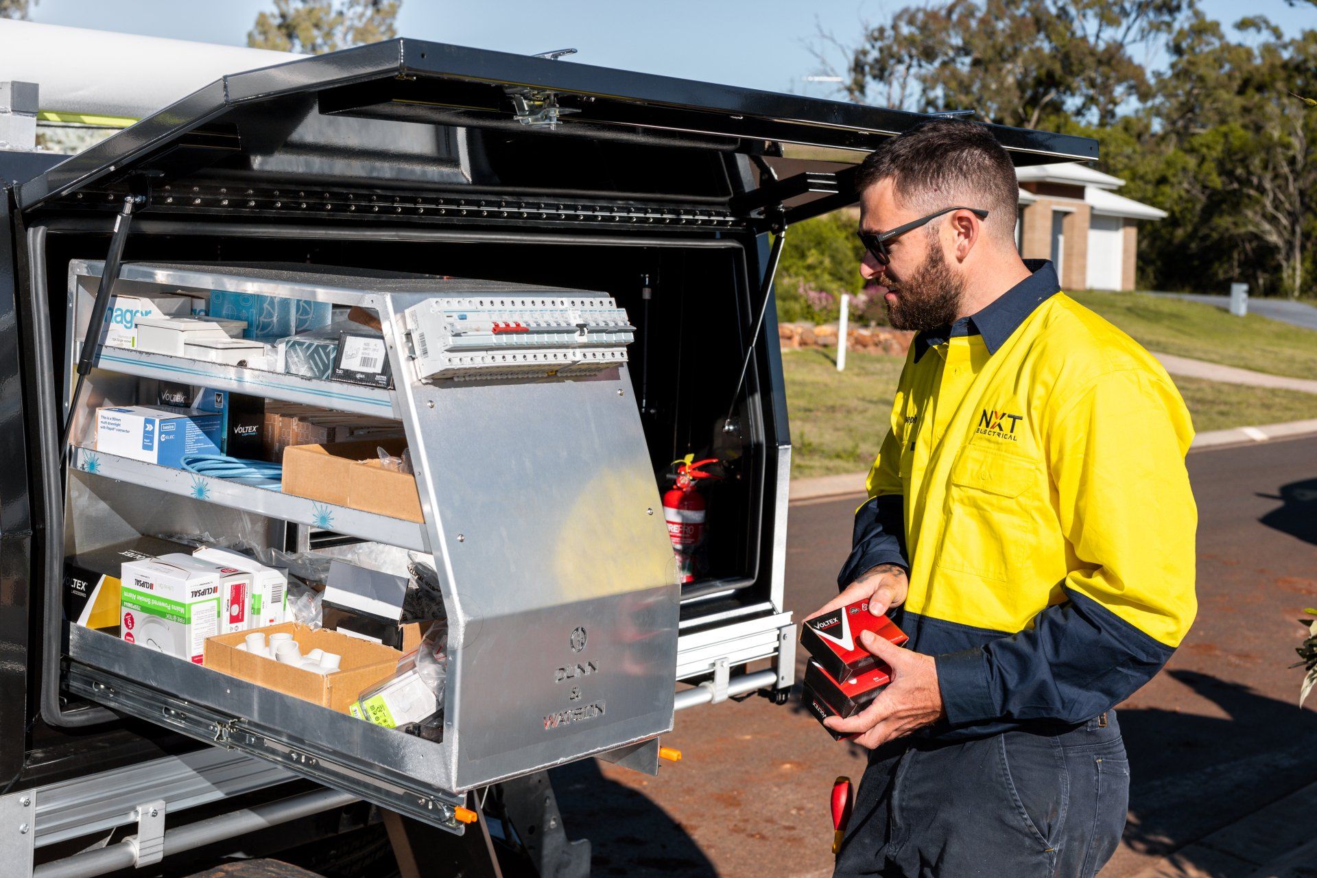 Worker loading supplies into a truck storage unit outdoors