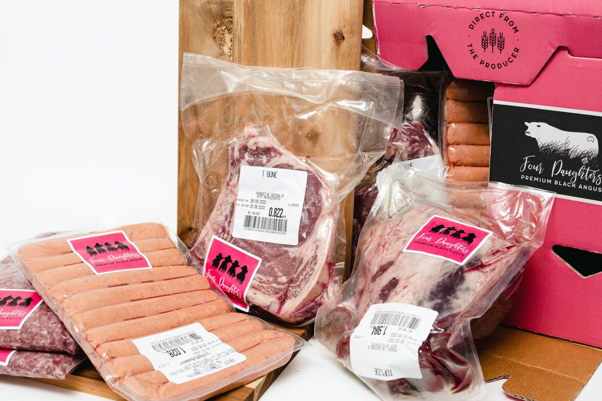 Packaged raw meat cuts in clear plastic with pink labels on a market display