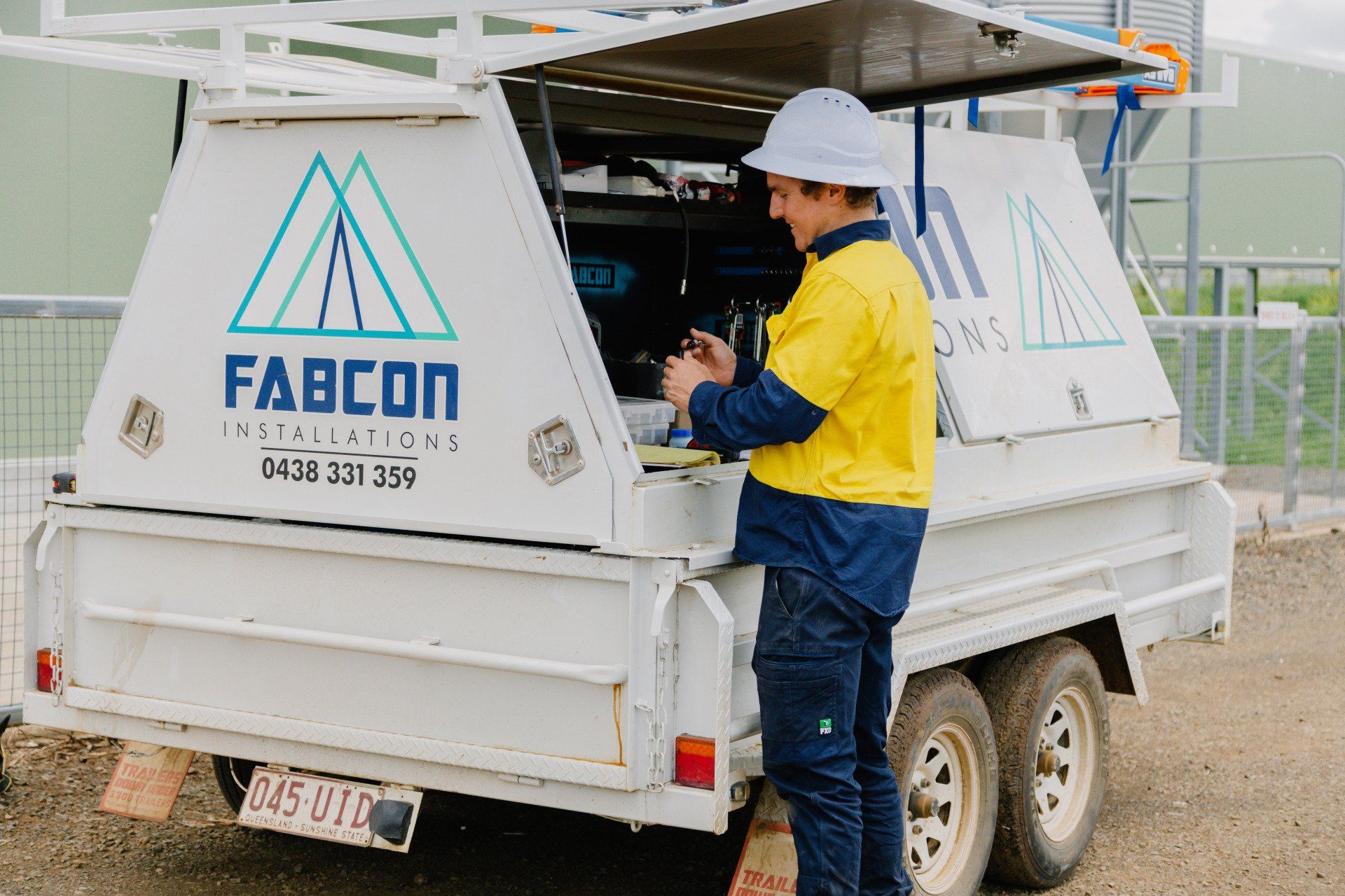 Worker in yellow jacket at a FABCON trailer in a warehouse