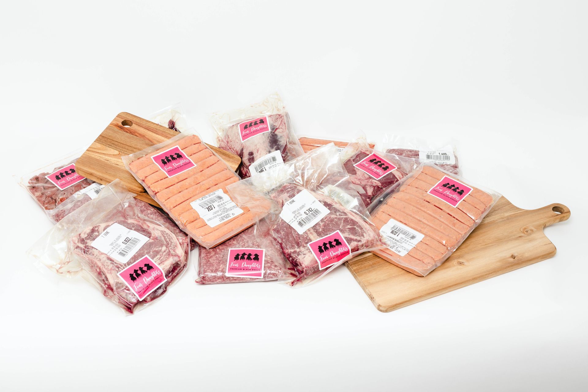 Assorted packaged meat cuts on wooden boards and trays against a white background
